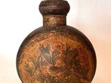 un petit vase marron orné d'un motif floral