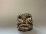 a close up of a stone object with a face on it