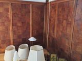 wooden paneled room with a lamp, picture frames, and picture frames on the floor