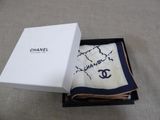 chanel scarf in a box on a carpeted floor