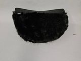 un sac à main noir orné de fourrure, posé sur un fond blanc