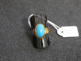 un gros plan d'une bague sertie d'une pierre turquoise