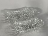 two clear glass containers sitting on a white surface