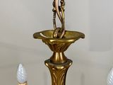 an image of a chandelier with three candles and a figurine on it
