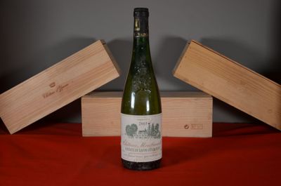a bottle of wine sitting on a table next to two wooden boxes