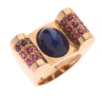 un gros plan d'une bague ornée d'une pierre bleue entourée de pierres roses