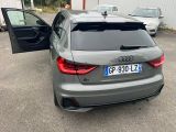 the rear end of a grey audi car parked in a parking lot