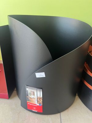 trois grands pots noirs posés par terre les uns à côté des autres