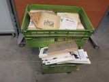a lot of papers in a green crate on the floor