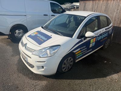 une petite voiture blanche garée à côté d'une camionnette blanche