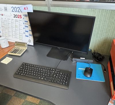 un bureau d'ordinateur sur lequel se trouvent un écran, un clavier et une souris