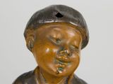 a small statue of a boy with a hat on his head