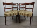 trois chaises en bois avec des assises rembourrées à rayures, devant un mur blanc