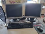 deux écrans d'ordinateur et un clavier sur un bureau