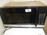 a microwave that is sitting on top of a washing machine