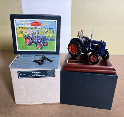 an old model of a tractor and a box with a picture of a man on it