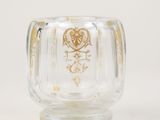 a clear glass vase with a gold design on it