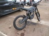 une moto tout-terrain garée sur un parking à côté d'une voiture