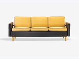 a black and yellow couch sitting on top of a white floor