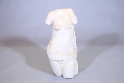 une statue blanche représentant une femme assise sur une table