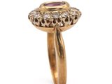 a close up of a gold ring with a ruby stone
