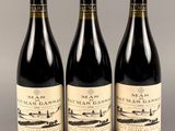 trois bouteilles de vin posées sur une table l'une à côté de l'autre