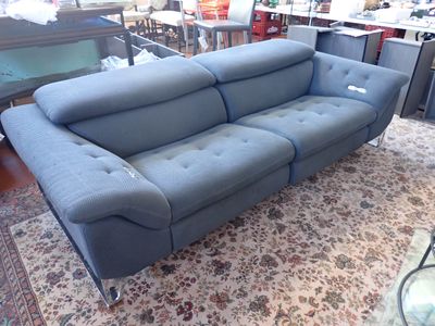 a blue couch that is sitting on a rug in a room
