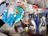 a plastic bag full of cleaning supplies on a bed