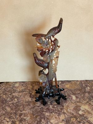 une statue représentant un oiseau perché sur une branche d'arbre