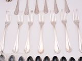 a lot of silver spoons and forks on the table