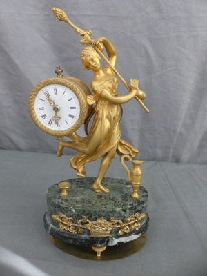 une statue de femme tenant une horloge sur une table