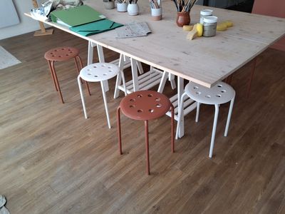 a table with four stools and a potted plant on top of it