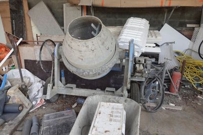 une bétonnière posée au milieu d'un tas de ferraille