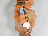 une sculpture réalisée à partir de cartons posée sur une surface blanche