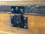 un gros plan sur un loquet métallique fixé à un coffre en bois