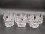 six verres transparents parsemés de petits points marron, posés sur une table