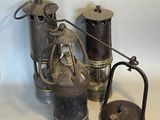 three different types of antique oil cans on a table