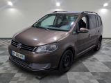 La camionnette marron est garée sur le sol à damier du garage.