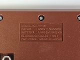 a close up of a brown electronic device on a white surface