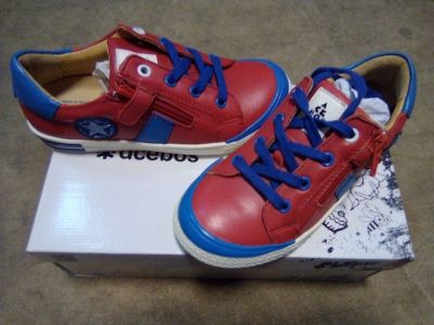 une paire de chaussures rouges et bleues posée sur une boîte