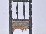 a small wooden chair with a small cushion on it