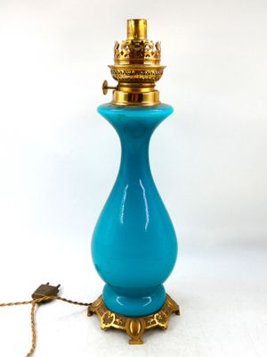 une lampe en verre bleu posée sur une table