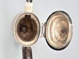 a silver cup and saucer sitting on a table