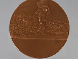 a bronze medal with a picture of a man in a top hat