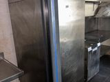 a stainless steel refrigerator in a kitchen with a bicycle parked in front of it