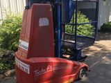 un chariot élévateur rouge garé devant un bâtiment