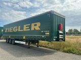 une semi-remorque verte garée sur le bord de la route