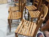 many wooden chairs in a room with a rug on the floor