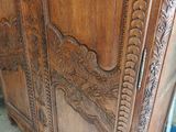 a wooden cabinet with carvings on it in a room