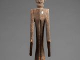a wooden statue of a man with a bird on his head